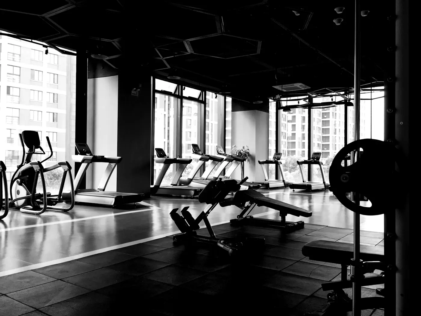 A gym floor lined with cardio machines and benches