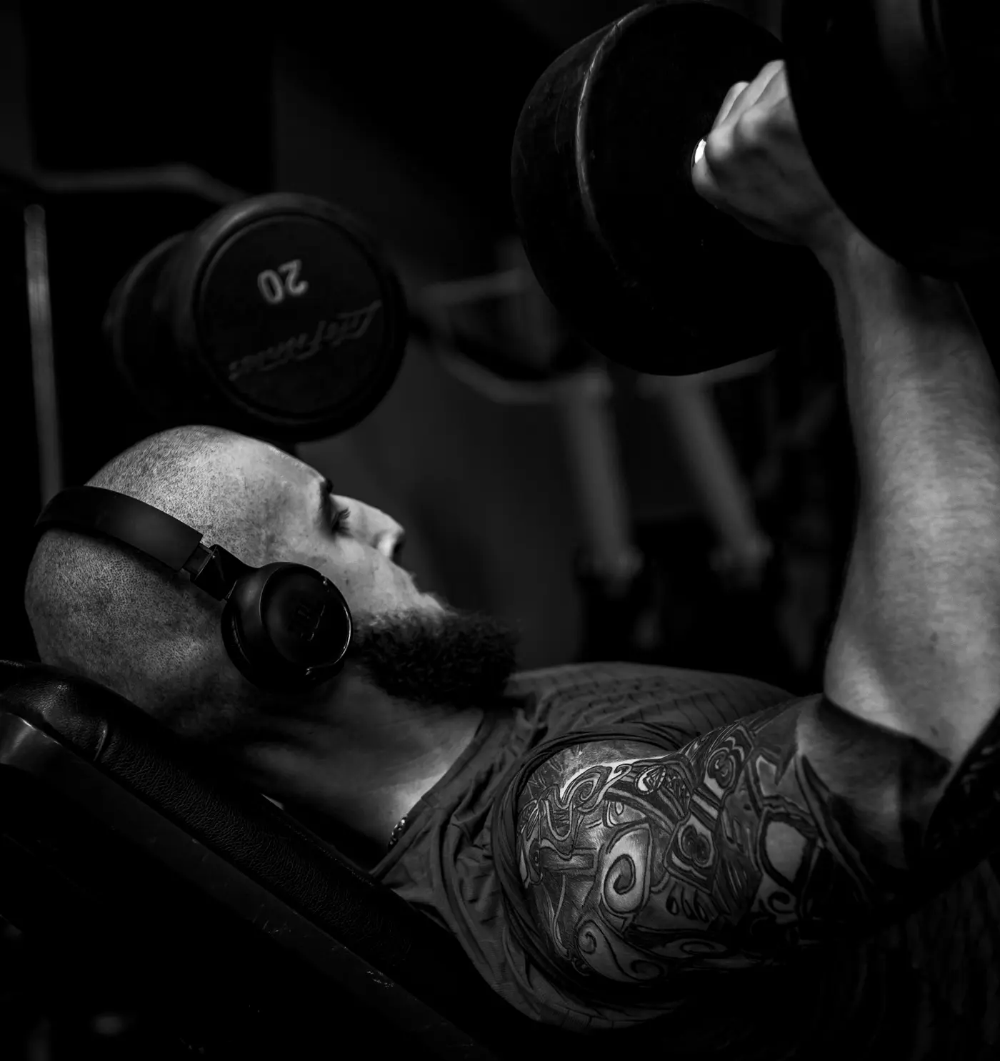 A lifter pressing dumbbells on an incline bench